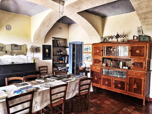 a room with a table with chairs and a book shelf at Agriturismo La Tilia in Lequio Tanaro