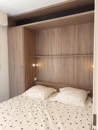 un lit avec deux oreillers dessus dans une chambre dans l'établissement Appartement confortable avec vue sur la mer à Quiberon - 25 m², à Quiberon