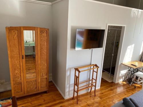 a room with a chair and a wooden cabinet at Heath Villa - private room in Port Elizabeth
