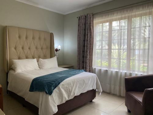 a bedroom with a bed and a large window at Sidze Guest House in Polokwane