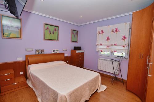 a bedroom with a white bed and purple walls at Apartamento Ama - 5828 in Isla