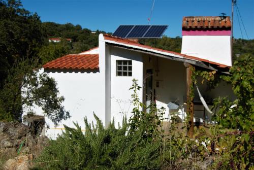 Casa blanca con paneles solares en el techo en TerraFazBem en Marvão