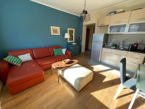 a living room with a red couch and a kitchen at Downtown Apartment in Kotor