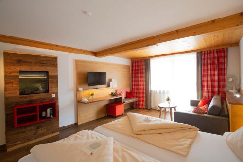 カウフボイレンにあるホテル アム カミンのベッドとリビングルームが備わるホテルルームです。