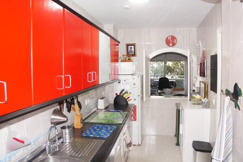 アルムニェーカルにあるTxistu HOME, Almuñécar Beachのキッチン(赤いキャビネット、シンク付)