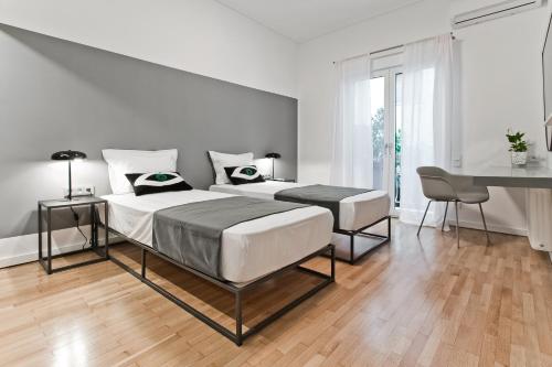 a bedroom with two beds and a desk in it at BAG- Boutique Apartment Grey - Hilton Area in Athens