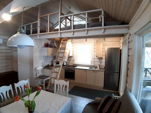 a kitchen with a loft bed in a tiny house at Šeimos namelis - Mindūnų sodyba in Mindūnai