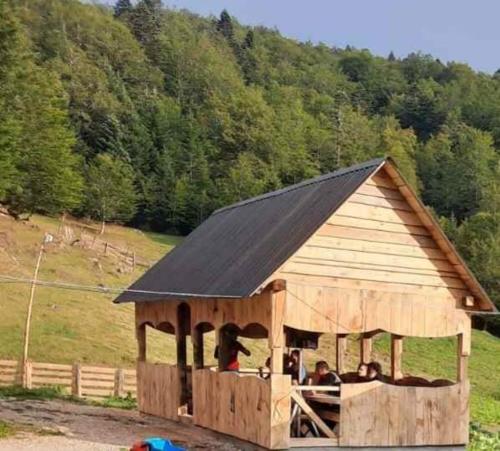 a large wooden barn with people sitting in it at Dulović - KATUN POTOCI in Kolašin