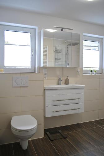 レンネシュタットにあるHaus Waldesruhのバスルーム(トイレ、洗面台付)、窓2つが備わります。