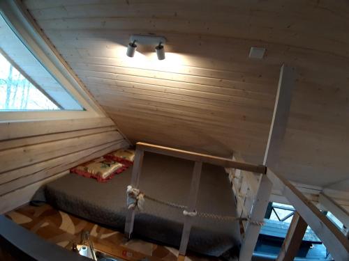 ein Schlafzimmer in einem winzigen Haus mit einem Bett darin in der Unterkunft Šeimos namelis - Mindūnų sodyba in Mindūnai