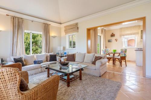 a living room with a couch and a table at Luxury two bedroom Palheiro Village by Holiday Rental Madeira in Funchal