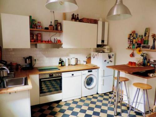 uma cozinha com electrodomésticos brancos e um piso xadrez em Charmante Dorfschule em Hohenhameln