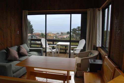 a living room with a table and chairs and a large window at Lodge Casa Vieja in Curanipe