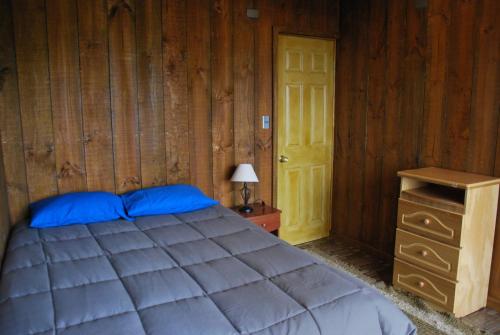 Lodge Casa Vieja في كيوراتايب: غرفة نوم بسرير وجدار خشبي