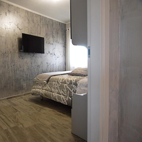a bedroom with a bed and a tv on a wall at A Casa di Lalla in Bracciano