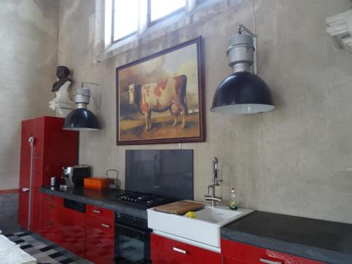 una cocina con fregadero y una pintura de una vaca en La chapelle de Melin, en Auxey-Duresses