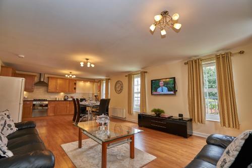 a living room with a couch and a table at Edinburgh Pearl Apartments - Haymarket Residence in Edinburgh