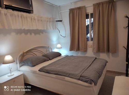 a bedroom with a bed with two lamps and a window at La Sabina in Mogán