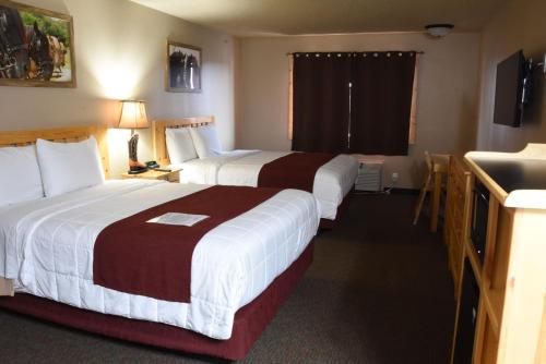 a hotel room with two beds and a television at Woodside Dells Hotel & Suites in Wisconsin Dells