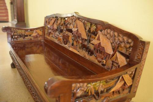 a wooden bench with a painting on the back of it at Kim Jek Cin 2 Hotel - โรงแรมกิมเจ็กซิน2 in Mukdahan