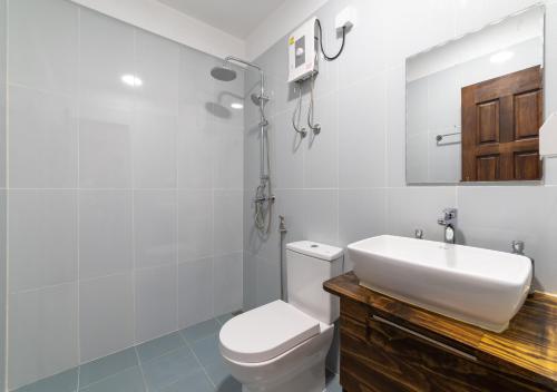 a white bathroom with a sink and a toilet at Beach Veli in Ukulhas