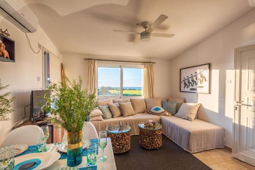 a living room with a couch and a table at Akamas Sunset Bohemian Chic Apartment by ONE VILLAS in Polis Chrysochous