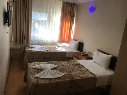 イスタンブールにあるÖrün Hotelのベッド2台と窓が備わるホテルルームです。