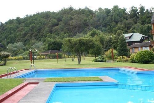 a large swimming pool in front of a house at Departamento en el Centro de Pucón, Hermosa vista al lago !! in Pucón