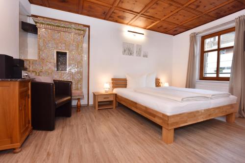 een slaapkamer met een groot bed en een televisie bij Landhaus Torghele in Schruns