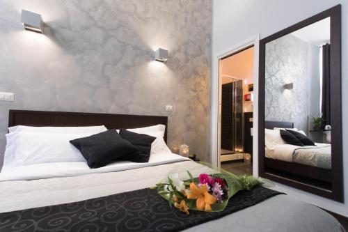 a bedroom with a bed with a bouquet of flowers on it at Chroma Italy - Chroma Pente in Rome