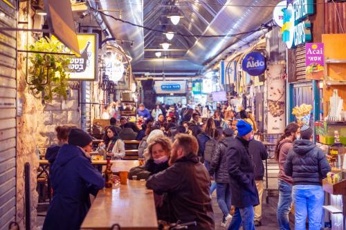 a crowd of people walking through a market with tables at Brown Machne Yehuda, a member of Brown Hotels in Jerusalem