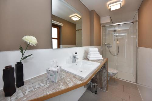 a bathroom with a sink and a toilet and a mirror at Landhaus Torghele in Schruns-Tschagguns