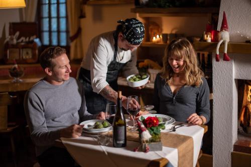 a group of people sitting at a table eating food at Hotel Zeni in Brentonico