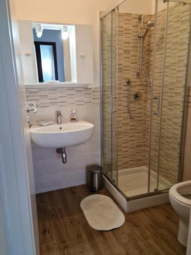 a bathroom with a sink and a shower and a toilet at Casa vacanze 'Sa Corbula' in Porto Columbu - Perdʼe Sali