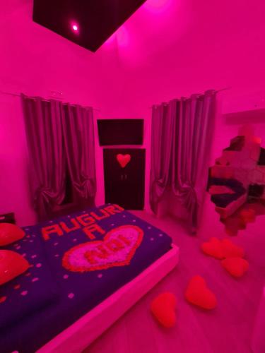 Habitación rosa con corazones en el suelo y cama en Costantinopoli Suite, en Giovinazzo