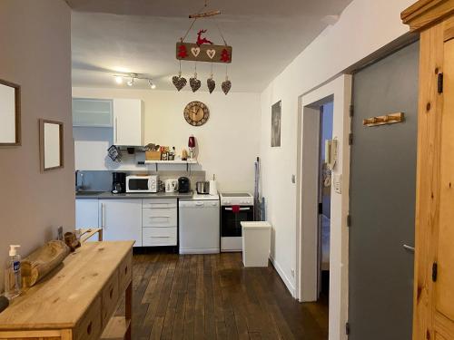 una cucina con elettrodomestici bianchi e tavolo in legno di Le Chellois appartement La Bresse a La Bresse