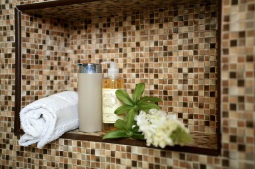 una mensola in bagno con dispenser per sapone e asciugamani di Casa Ana a Nazaré