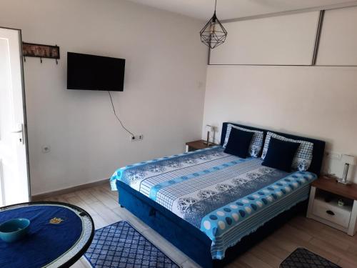 a bedroom with a bed with a tv on the wall at Casa Calda Apartments in Cetinje