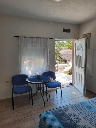 a table and chairs in a living room with a patio at Casa Calda Apartments in Cetinje