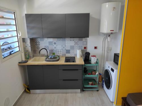 a small kitchen with a sink and a stove at STUDIO RENOVé # LA RESERVE # in Sainte-Clotilde