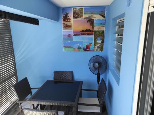 een eetkamer met blauwe muren en een tafel en stoelen bij STUDIO RENOVé # LA RESERVE # in Sainte-Clotilde