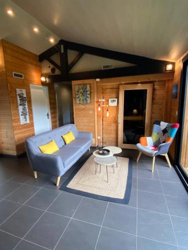a living room with a blue couch and two chairs at La Cabane d'Arès - chambre double PREMIUM in Arès