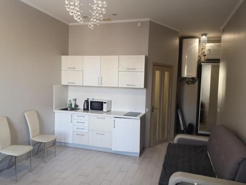 een keuken met witte kasten en een magnetron bij Welcome Apartments Center in Kiev