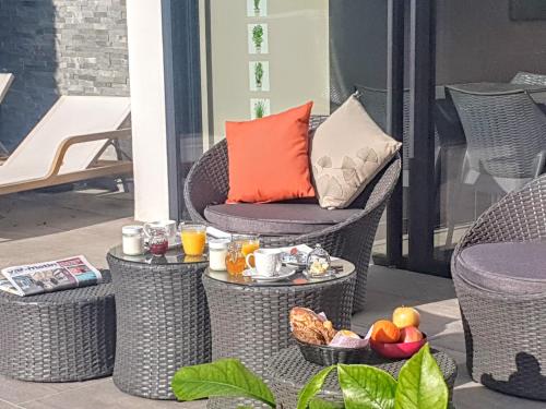 un patio con sedie in vimini e un tavolo con frutta di La Villa Blanche a Sanary-sur-Mer