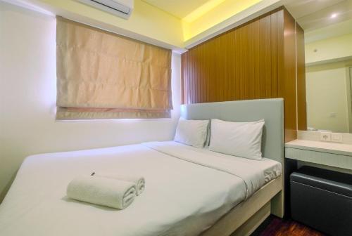 a bedroom with a white bed with a towel on it at New Furnished and Minimalist 3BR at Meikarta Apartment By Travelio in Cikarang