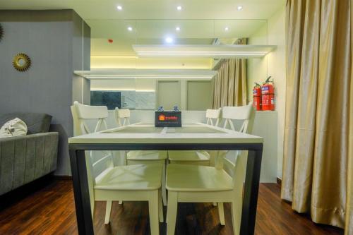 a dining table and chairs in a living room at New Furnished and Minimalist 3BR at Meikarta Apartment By Travelio in Cikarang