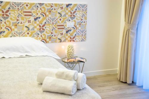 a bedroom with a bed and a table with towels at Accòmodati - Camere e Appartamenti in Marina di Gioiosa Ionica