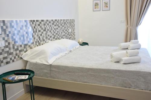 a bedroom with a bed with white sheets and pillows at Accòmodati - Camere e Appartamenti in Marina di Gioiosa Ionica
