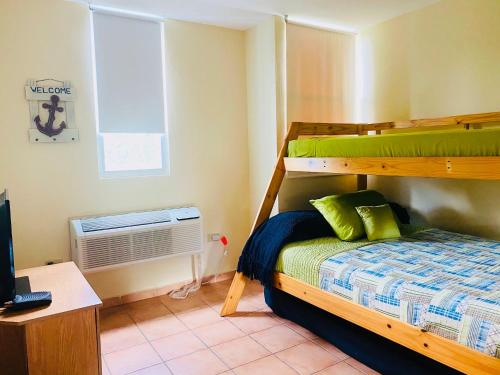 - une chambre avec des lits superposés et une fenêtre dans l'établissement Villas Del Mar Beach Resort, à Loiza