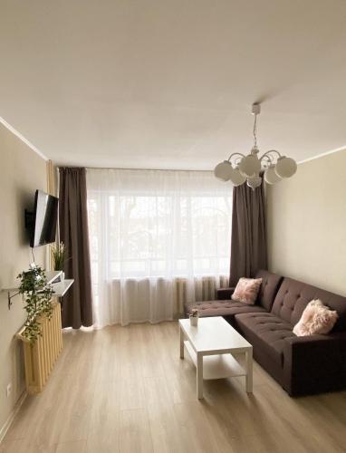 a living room with a couch and a table at Apes ielas apartaments in Alūksne
